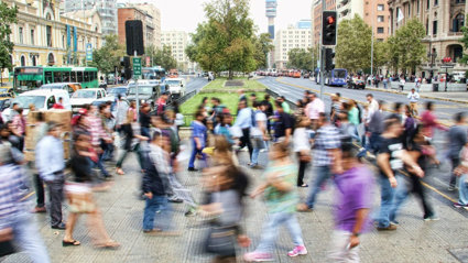 People in motion crossing a busy street.