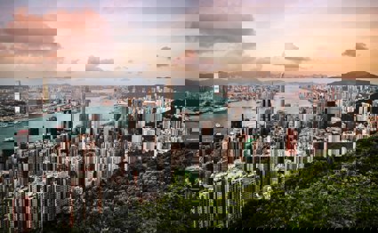 A view over Hong Kong, showing a cityscape, river and woodlands