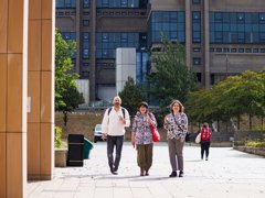 Three people standing beside a modern building.