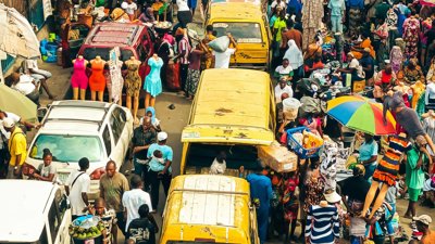 Yellow vans seen travelling down a busy street in Nigeria.