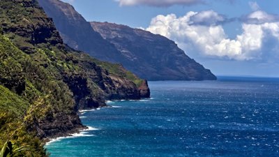 A view of mountains with the ocean in the background.