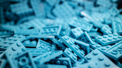 A pile of blue, rectengular lego blocks.