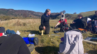 A tutor demonstrating fieldwork in the outdoors.
