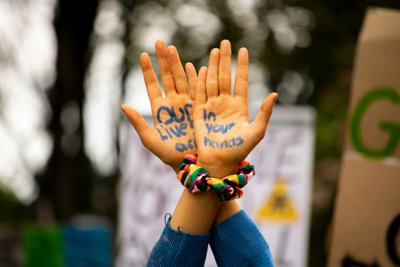 Our lives in your hands written on a pair of hands held in the air