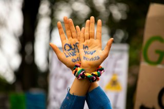 Our lives in your hands written on a pair of hands held in the air