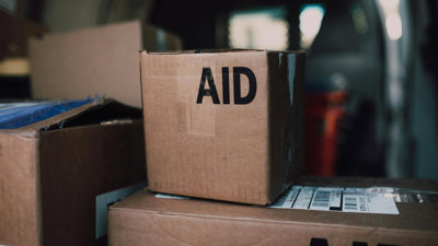 Cardboard boxes stacked on top of eachother, displaying the word 'Aid'.