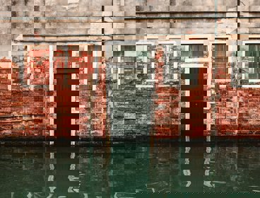 Flood water rising in front of a black front door