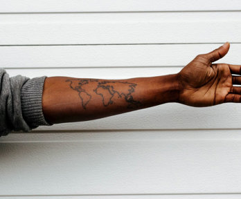 An arm with a tattoo of a map of the world.