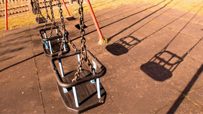Four empty swings in playground park.
