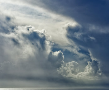 Moody grey clouds forming over the sea - you can see light bouncing off the edges of the clouds