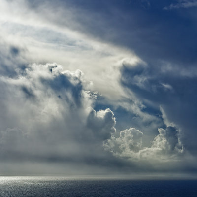 Moody grey clouds forming over the sea - you can see light bouncing off the edges of the clouds