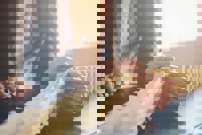 Person's hand over a set of dominoes