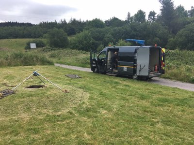 An operative lowers sensors down a borehole to measure temperature levels