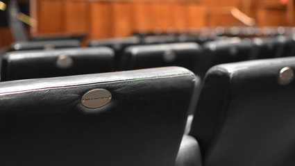 A close up of black leather chairs in a lecture hall. 