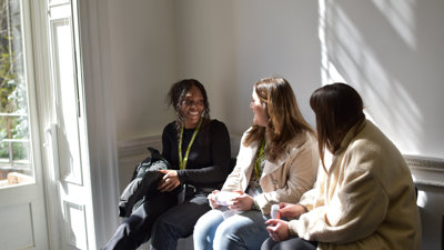 Three postgraduates chatting to each other at conference.