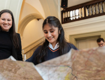 A young person looking at a large map.