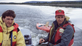 Two people on a small motorised boat.