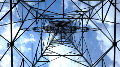 The view up the middle of an electricity pylon, viewed from the ground up.
