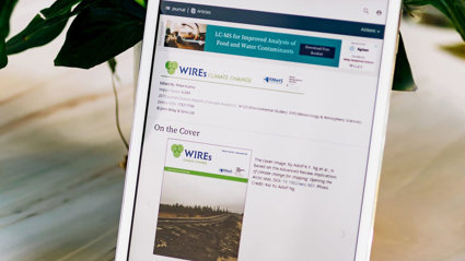 Tablet leaning on a plant pot. The sceen displays the WIREs journal homepage.