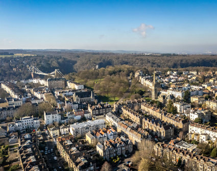 Urban view from above showing residental areas and a suspension bridge