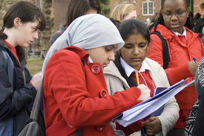 Two female students looking together at a clipboard