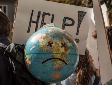 Globe with sad face added on amongst global warming and climate change rally.