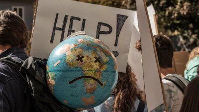 Globe with sad face added on amongst global warming and climate change rally.