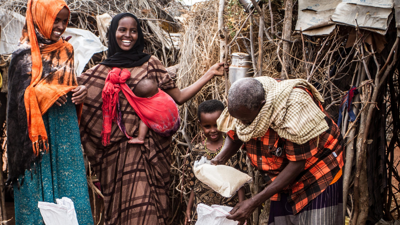 Group of people with straw and stick structures behind them