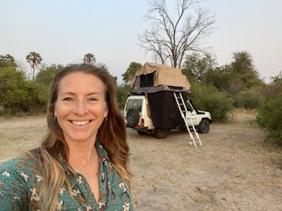 Charlotte standing in front of 4x4 vehicle with a tent on top