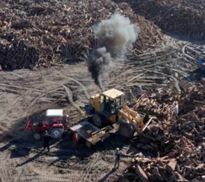 An aerial view of logged wood with industrial vehicles