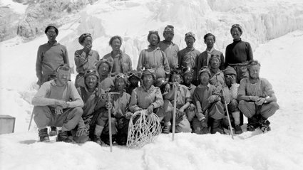 Black and white photograph of a group of sherpas posing with Noyce and Wylie on South Col.