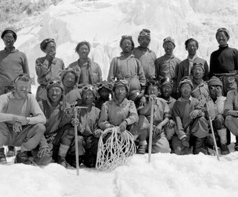 Black and white photograph of a group of sherpas posing with Noyce and Wylie on South Col.