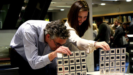 Two people looking at slides in folders.