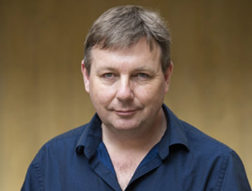 Headshot of a person wearing dark blue shirt.