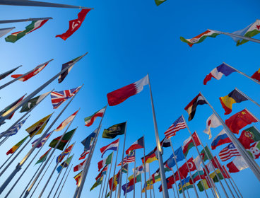 Multiple Flags Flying In Blue Sky
