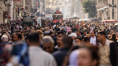 Shot of busy crowd on a street during daytime with buildings on both sides