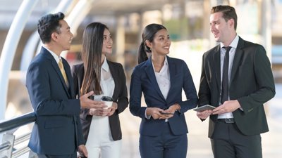 Four people in business suits stood talking.