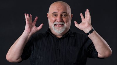 Alexei Sayle against black background.