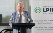 Michael Woods speaking behind a lectern at a Rural Wales Local Policy and Innovation Partnership (LPIP) event.