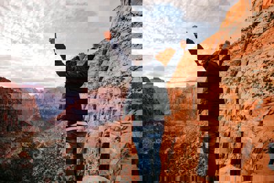 Person with hands in the air overlooking Grand Canyon