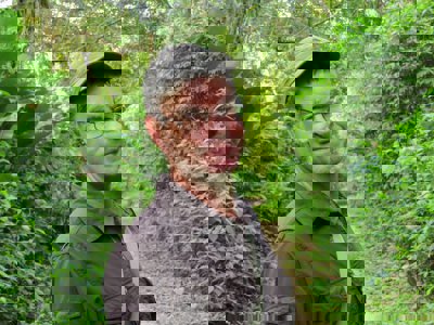 Mark Wright standing on a path with trees surrouning him