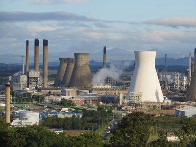 An aerial view of a power station, showing chimneys and smoke