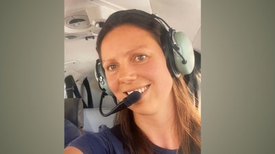 Plum Turner wearing headphones on plane. 