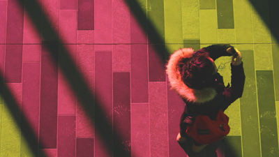 Aerial view of a person standing with a phone on a pink and yellow floor