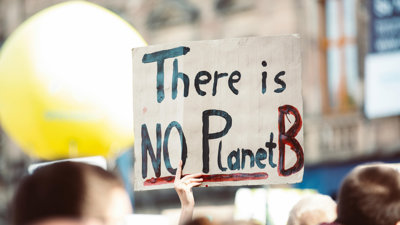 Hand holding a 'there is no planet B' placard.