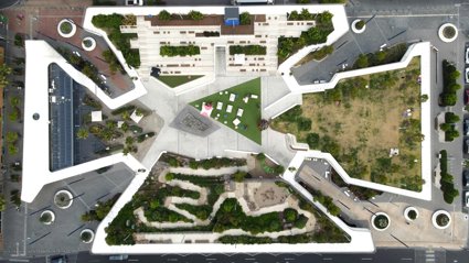 Aerial view of a building with green spaces.