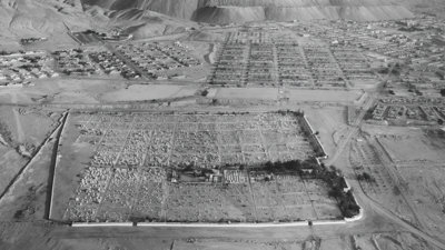 Black-and-white photograph of an open-pit copper mine as seen from above.