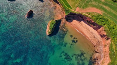 Aerial view of a coastline showing a bay and coastal stacks.
