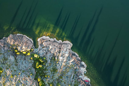 Ariel view of rocky land at water's edge and body of water.
