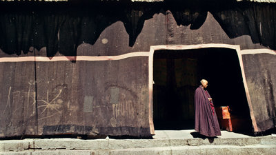 A lone monk in a monestary in Tibet.